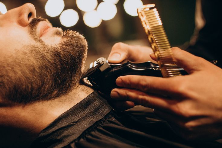 Handsome man at barbershop shaving beard